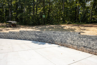 Retaining wall made of gray bricks with a forest background