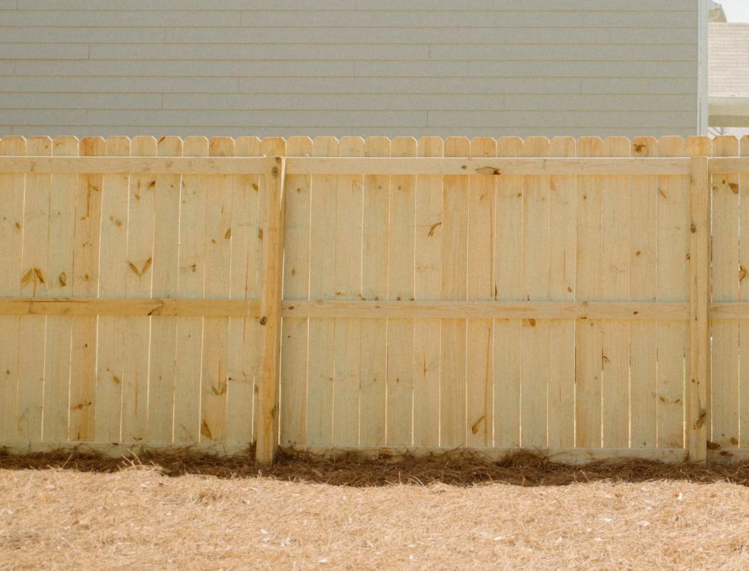 Wooden fence in front of a house with a neutral background