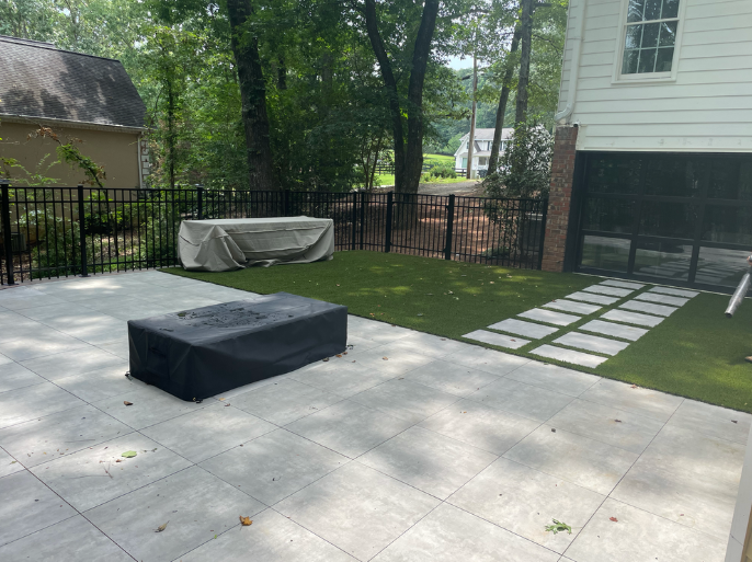 Backyard with patio, fire pit, and grass area.