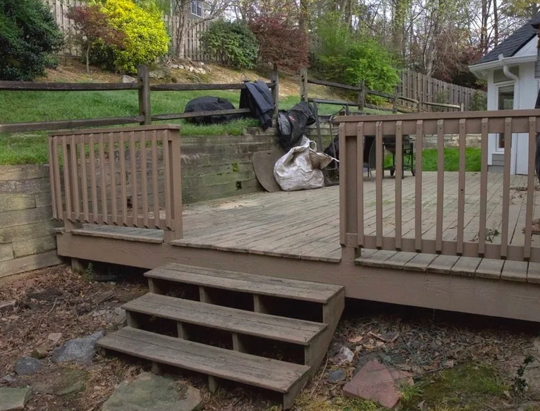 Broken wooden deck with steps leading down to a grassy area