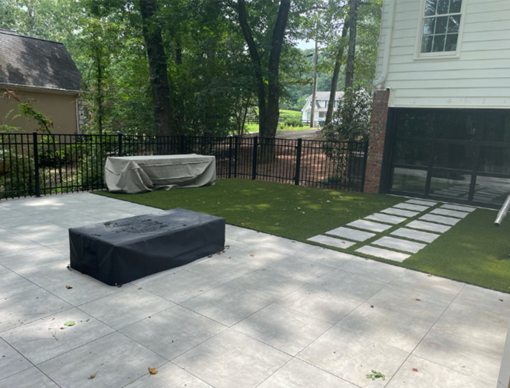 Backyard with patio, fire pit, and grass area near a house