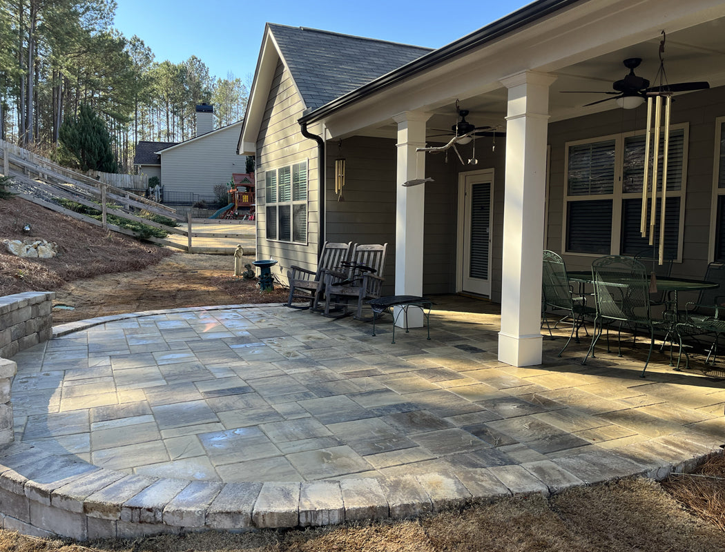 Elegant custom paver patio with integrated natural stone walkway leading to house entrance, complete with stylish outdoor furniture seating area in Marietta, GA