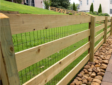 Wooden fence with wire mesh on a grassy area